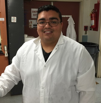 Jacob Palacio standing in a white lab coat
